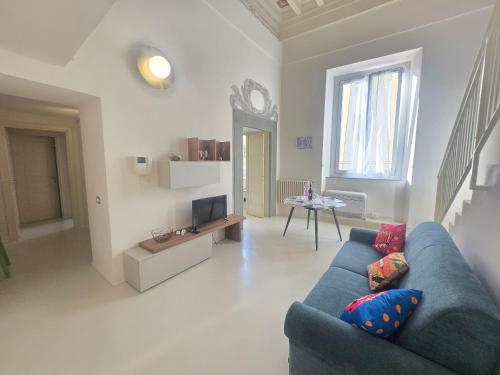 a living room with a blue couch and a tv at Fabroniana apartment Elegant in Pistoia