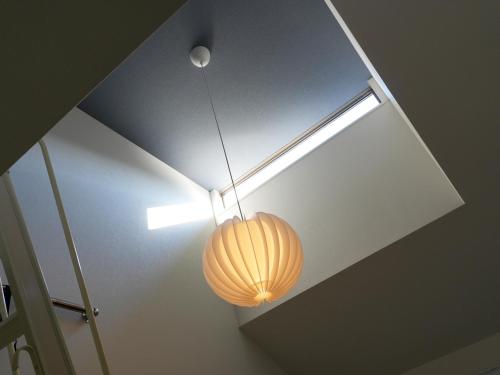 a lamp hanging from a ceiling with a light at OUCHI HOTEL Onaganishi in Hiroshima