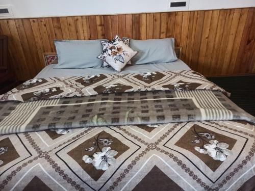 a bed with a quilt and pillows on it at Apple view Homestay in Banjār