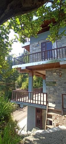 a house with a deck on the side of it at Apple view Homestay in Banjār