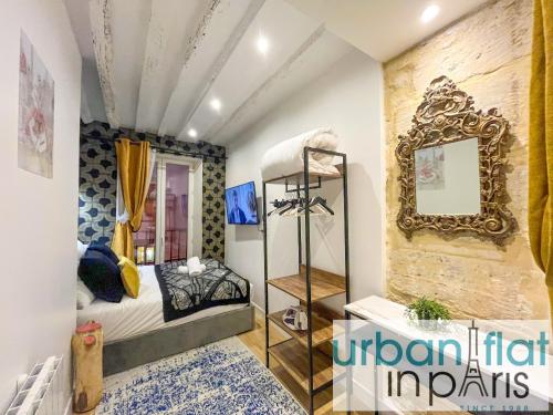 une chambre avec un lit et un miroir dans l'établissement 15 - Coco Chanel Montorgueil, à Paris
