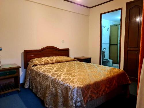 a bedroom with a bed and a bathroom at Hostal Recoleta Sur in Sucre