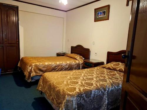 a room with two beds in a hotel room at Hostal Recoleta Sur in Sucre
