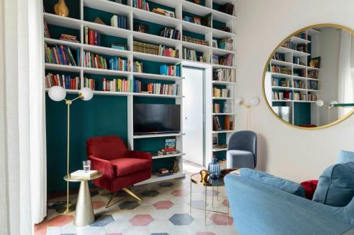 a living room with a large book wall with a mirror at YCH-Colosseo book house in Rome
