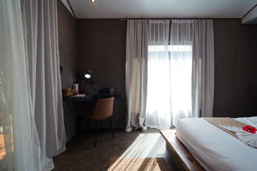a bedroom with a bed and a desk and a window at Inigtan Lio Villas in El Nido
