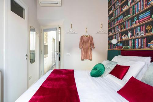 a bedroom with a large white bed with red pillows at YCH-Colosseo book house in Rome