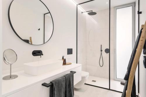 a white bathroom with a sink and a mirror at LuxLiving Tenerife Villa Balansa in Adeje