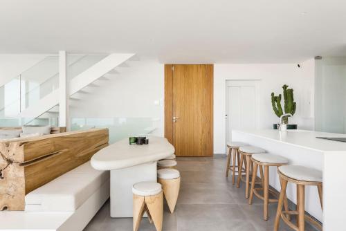 a kitchen with a white counter and stools at LuxLiving Tenerife Villa Balansa in Adeje