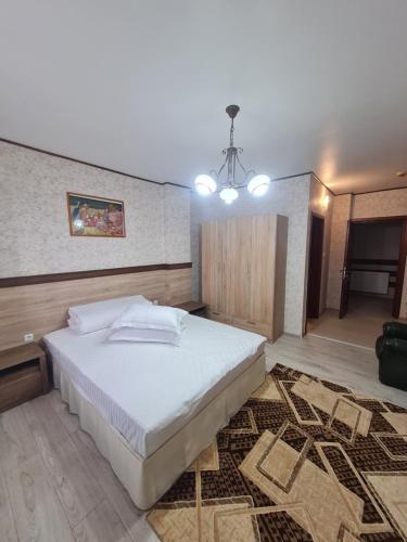 a bedroom with a large white bed and a rug at Casa Central in Tîrgu Neamţ