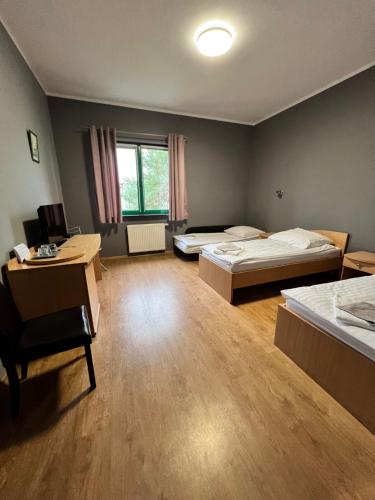 a room with two beds and a desk in it at Akademia Tenisa Prawobrzeże in Szczecin