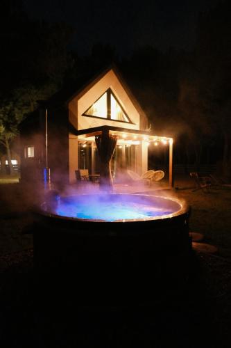 a fountain in front of a house at night at Osada pod Gwiazdami & SPA - FAMILY ogrodzony dom, prywatne JACUZZI, kominek, grill, ognisko, Kajaki, Plaża, Jeziora in Łasko