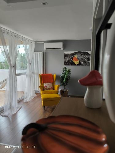 a living room with a yellow chair and a couch at Apartman Lamarti in Samobor