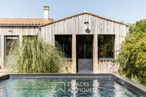 une maison en bois avec une piscine en face de celle-ci dans l'établissement Villa à deux pas de l'Océan, à Saint-Pierre-dʼOléron