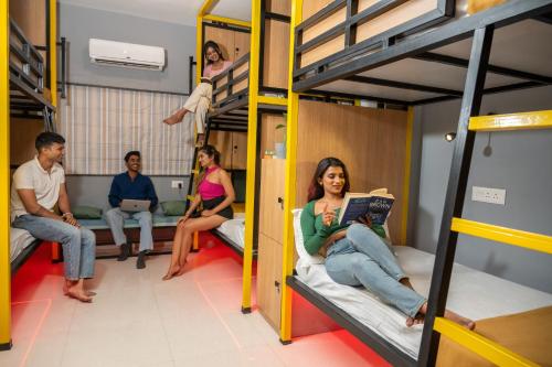 a group of people sitting in bunk beds at Vib O Stay in Pune