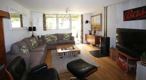 a living room with a couch and a tv at Eco Friendly beach house in Camber