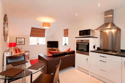 a kitchen and living room with a couch and a table at DBS Serviced Apartments - The Twain in Castle Donington