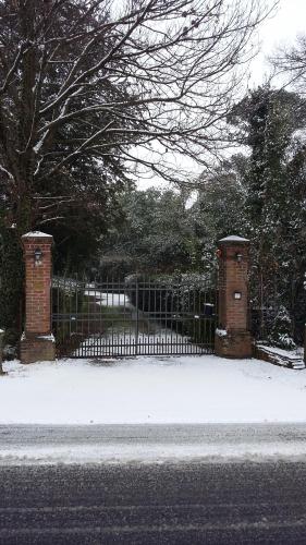 a gate with a fence with snow on the ground at Villa Mainardi Agriturismo in Camino al Tagliamento