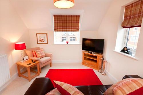 a living room with a couch and a television at DBS Serviced Apartments - The Twain in Castle Donington