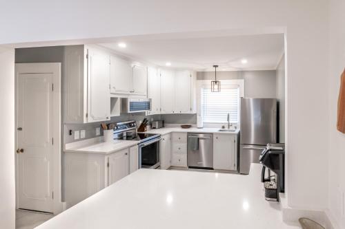 a kitchen with white cabinets and stainless steel appliances at White Mountain Escape in Littleton