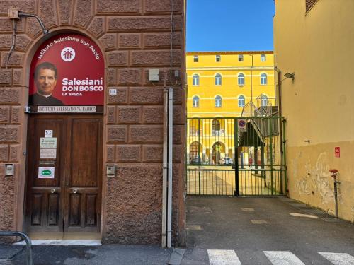 a door to a building with a sign on it at Ostello San Giovanni Bosco in La Spezia