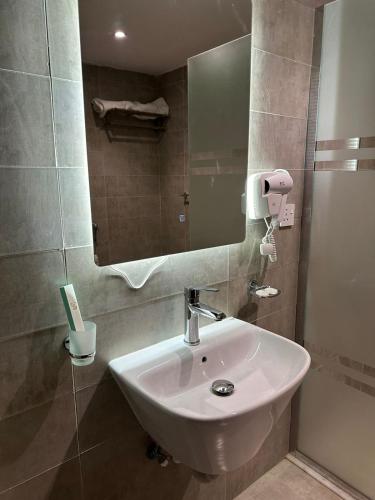 a bathroom with a white sink and a mirror at فندق نسمات in Al Madinah