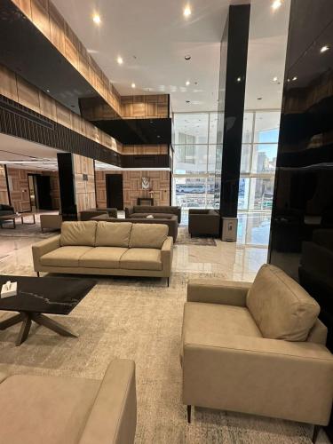 a living room with couches and tables in a building at فندق نسمات in Al Madinah