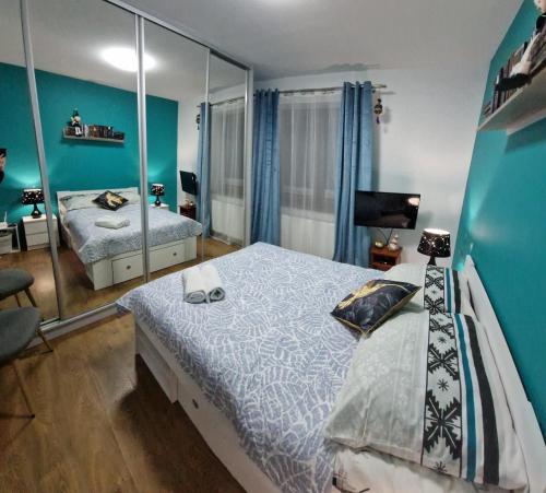 ein Schlafzimmer mit einem Bett und einem Spiegel in der Unterkunft Apartament Gwiazda przy Stoku na parterze z ogródkiem in Krynica-Zdrój