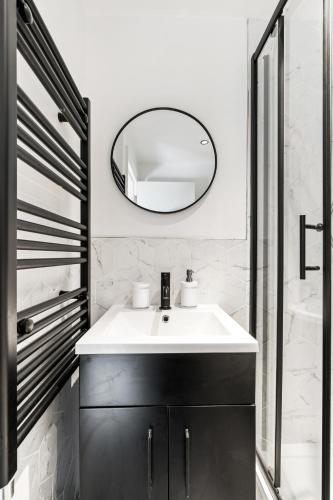 a bathroom with a white sink and a mirror at Sea Breeze Escape in Brighton & Hove