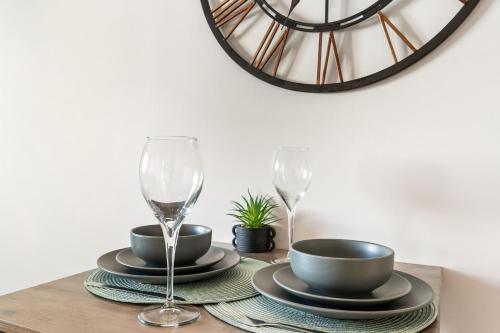 a table with two glasses and plates and a mirror at Sea Breeze Escape in Brighton & Hove