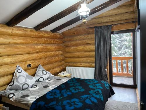 una camera da letto con un letto e una parete di legno di Cabanele Silvania a Borsa