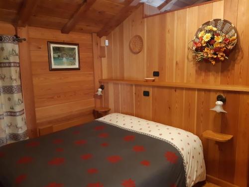 Un dormitorio con una cama y una corona de flores en la pared. en L'Etoile Du Berger, en Lillianes