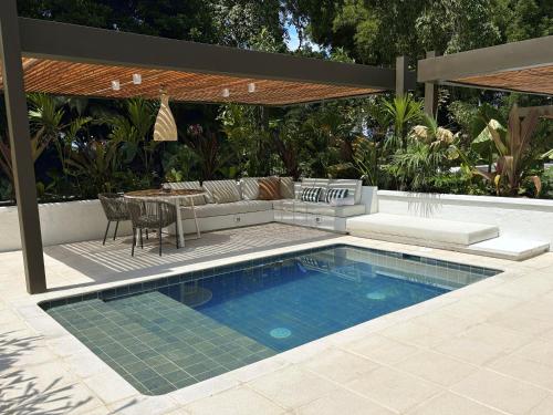 a pool in a backyard with a couch and a table at Hacienda Bambusa in El Caimo