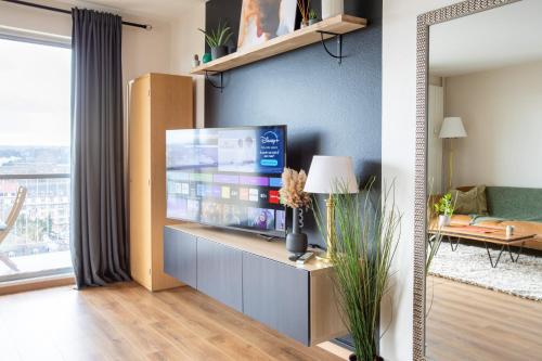 un salon avec une grande télévision à écran plat dans l'établissement Nouveau, Vue incroyable, terrasse & confort, à Mulhouse