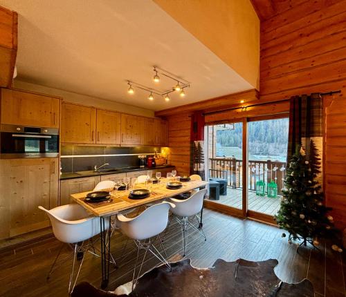 une cuisine avec une table et des chaises et un sapin de Noël dans l'établissement Chalets d'Angèle D5 - Multipass inclu, à Châtel