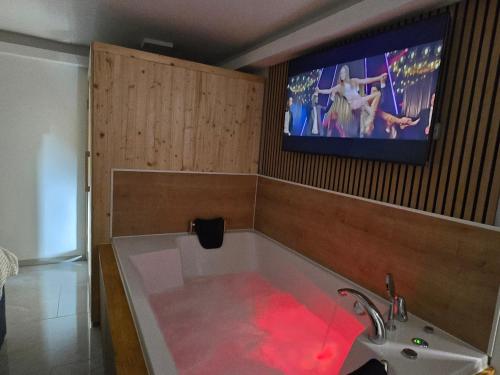 eine Badewanne mit einem TV an der Wand in der Unterkunft Edy Deluxe Room - Sauna & Jacuzzi in Zagreb