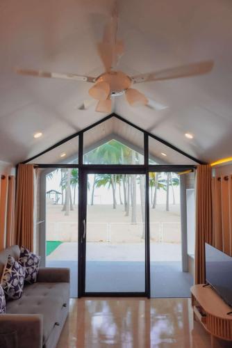 a living room with a ceiling fan and a couch at W Sichon Beachfront Homestay in Ban Kho Khao