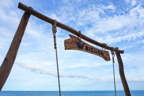 a wooden sign on a boat in the ocean at W Sichon Beachfront Homestay in Ban Kho Khao