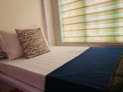 a bed with a pillow next to a window at VILLA CALATHEA Varkala in Varkala