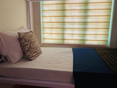 a bed with two pillows sitting on it in front of a window at VILLA CALATHEA Varkala in Varkala