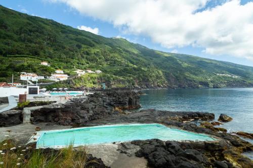 a pool on the shore of a body of water at Casas do Amarelo in São Mateus