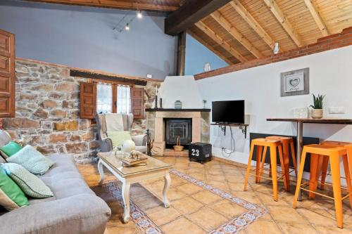 a living room with a couch and a fireplace at Carbayu Senda del Oso in Proaza