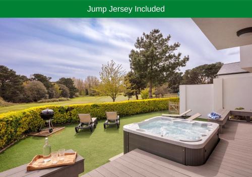 a hot tub in a backyard with a lawn at Les Ormes Resort in St Brelade