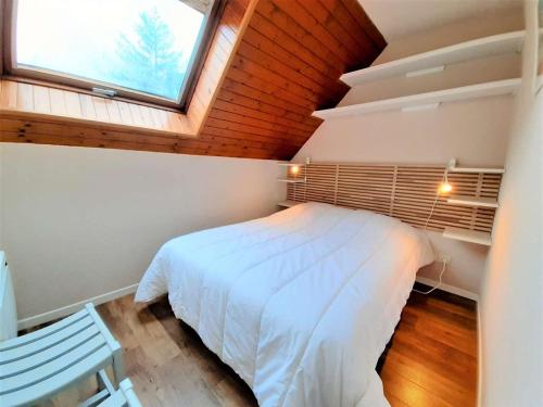 une chambre avec un lit blanc et une fenêtre dans l'établissement Charmant T2 Sud avec Bow-Window, TV, Kitchenette Équipée, Muscu, Sauna, Jacuzzi—Proche St-Lary Soulan - FR-1-457-284, à Vignec