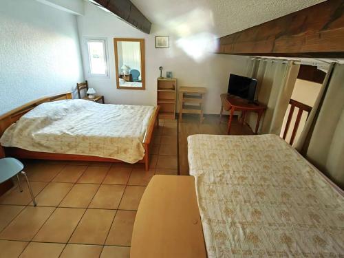 - une chambre avec 2 lits et une télévision dans l'établissement Villa climatisée avec piscine, parking et terrasse à 450m de la plage - FR-1-607-17, au Cap d'Agde