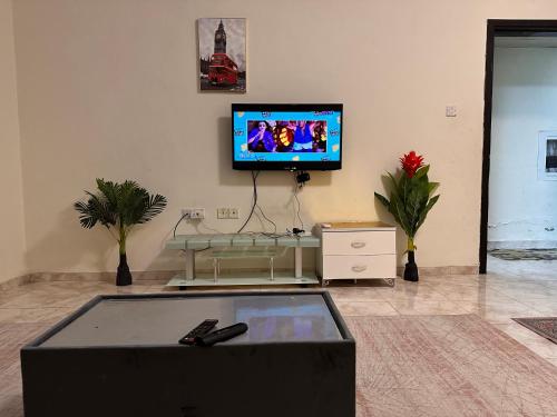 a living room with a flat screen tv on the wall at City view furnished room in Ajman