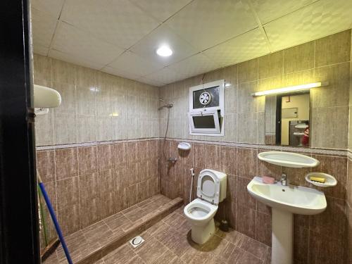 une salle de bain avec toilettes et lavabo dans l'établissement City view furnished room, à Ajman