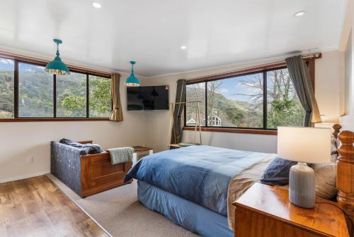 a bedroom with a bed and some windows at River Valley Escapes in Thames
