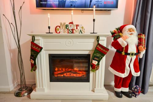 a santa claus standing next to a fireplace at CityScape Bucharest in Bucharest