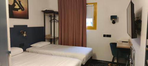 a hotel room with two beds and a television at Welcomotel Beauvais Aéroport in Beauvais