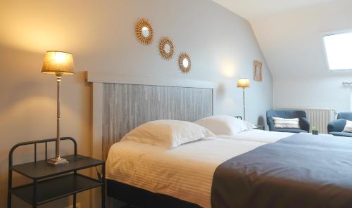 a hotel room with a bed and a chair at Le Relais De La Motte in Soignies